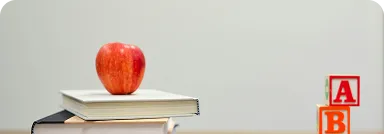 alphabet blocks and an apple on books